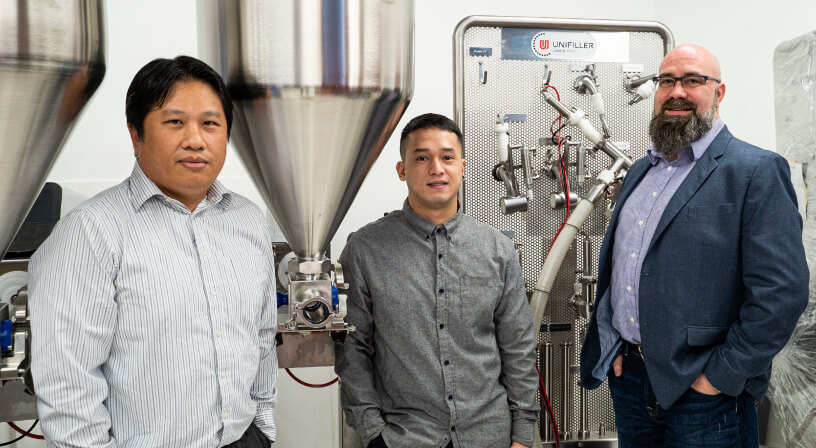 Coperion employees posing with machinery